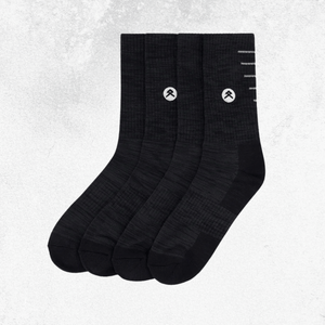 Four black crew socks arranged in a fan shape on a light gray textured background. Each sock features a small white circular logo with a stylized mountain symbol and a few white horizontal lines near the top.
