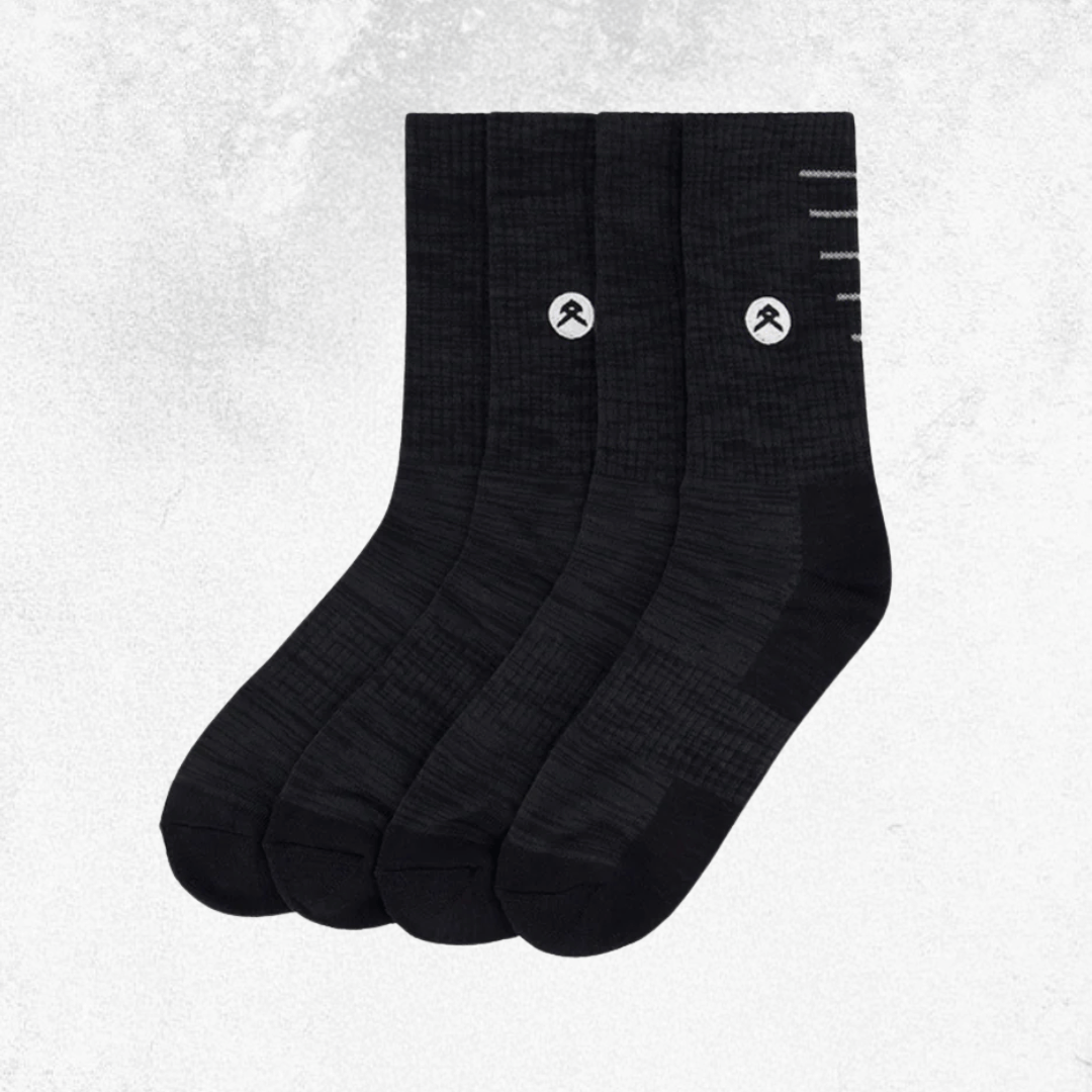 Four black crew socks arranged in a fan shape on a light gray textured background. Each sock features a small white circular logo with a stylized mountain symbol and a few white horizontal lines near the top.
