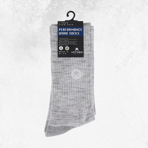 A pair of light gray ribbed crew socks hanging from a black plastic hanger with a black and blue retail tag. The tag reads 'PERFORMANCE WORK SOCKS' and shows the brand Anthem.