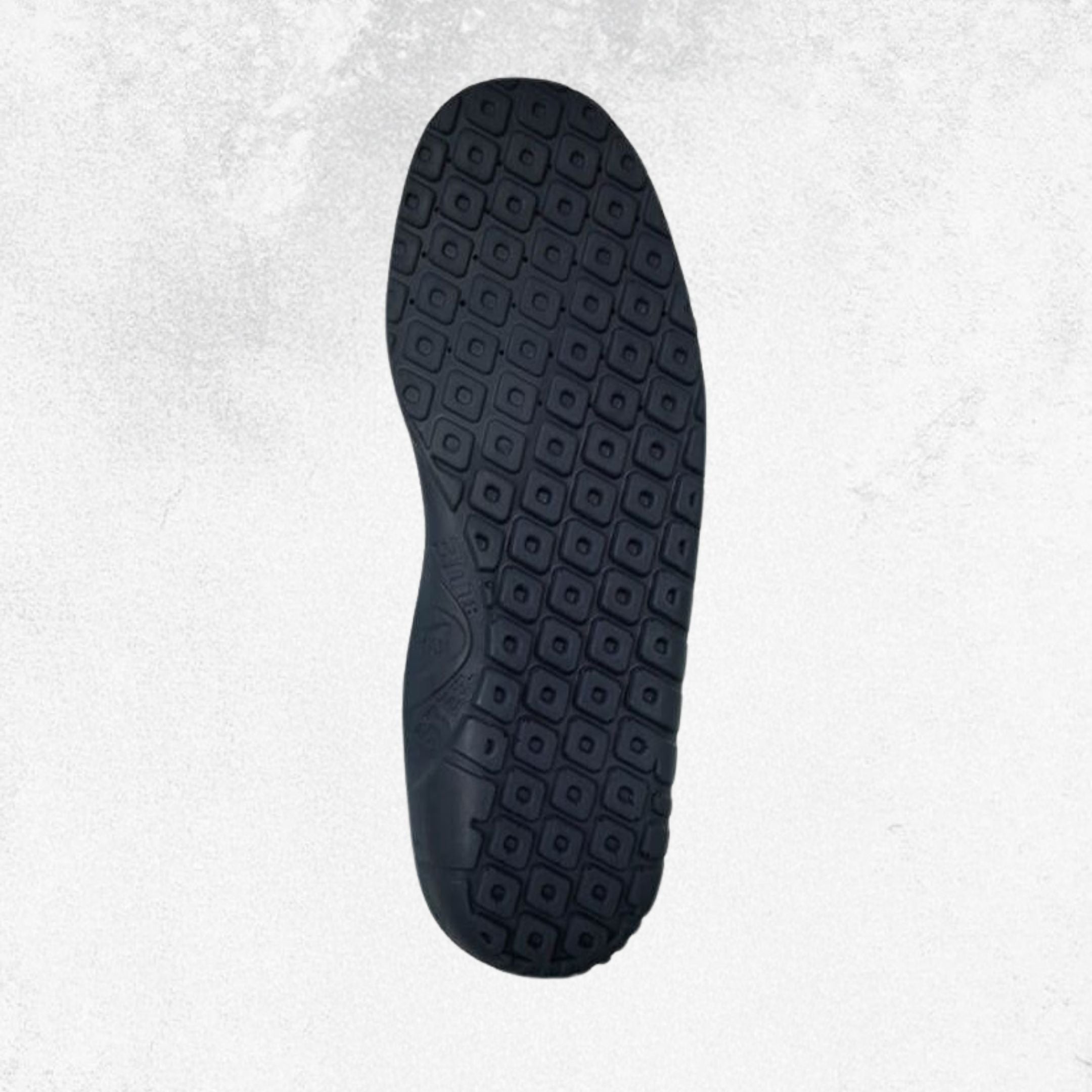 A top-down view of a black shoe sole with a detailed geometric tread pattern, set against a light gray textured background.