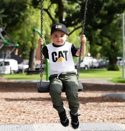 Kid swinging on a swing set in park
