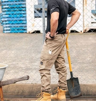 A man standing with a spade wearing UNIT Demolition Cuffed Pant