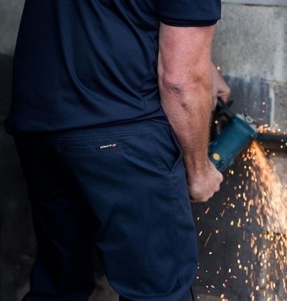 Man cutting with angle grinder wearing UNIT Pro-Flex Polo