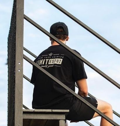 Man Wearing Unit Workwear clothing sitting on grandstand. 