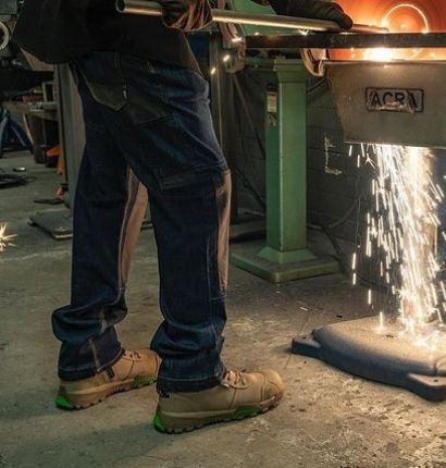 Man working in FXD WD-3 Taper Jeans grinding metal. 