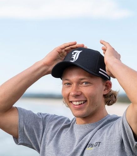 Young man holding his hands to his head wearing the JetPilot Times Cap. 