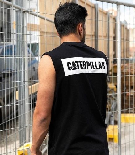 Man standing on construction site wearing the CAT Icon Muscle Tank Tee 