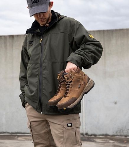 Man Holding Boots wearing the CAT Chinook Waterproof Jacket