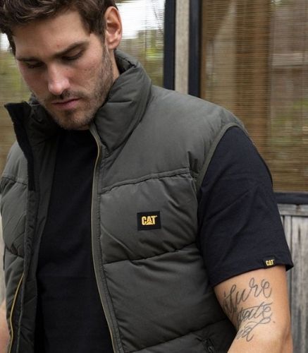 Man outside looking at ground wearing the Cat Artic Zone Vest