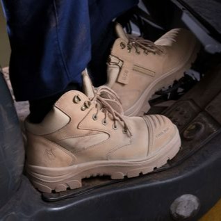 A boot angled  with legs on brake in a vehicle