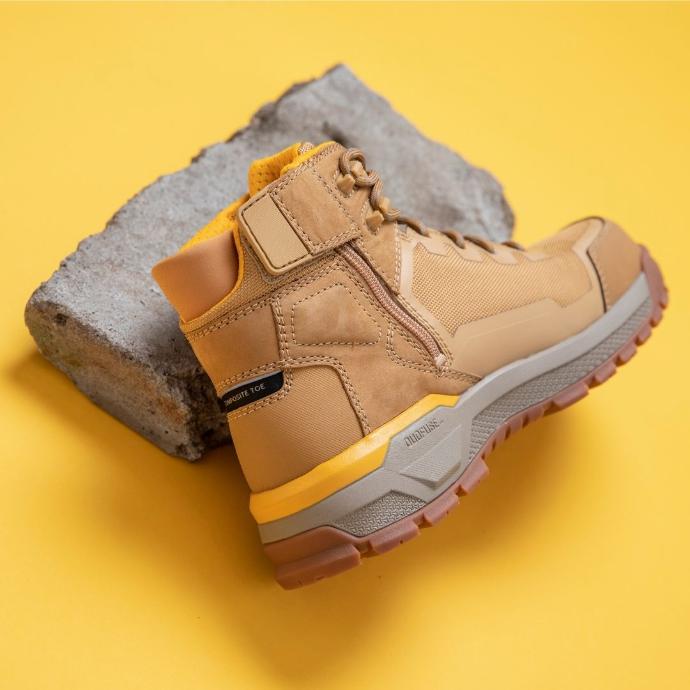 Cat Propulsion | Man Cave Workwear The Cat Propulsion boot on a concrete block with yellow background