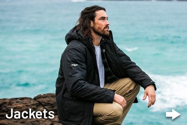 Australian tradie Man outside near ocean wearing Jetpilot Workwear jacket.