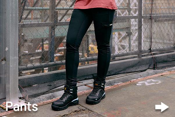 Women tradie wearing CAT workwear boots and Pants on construction site during the day.